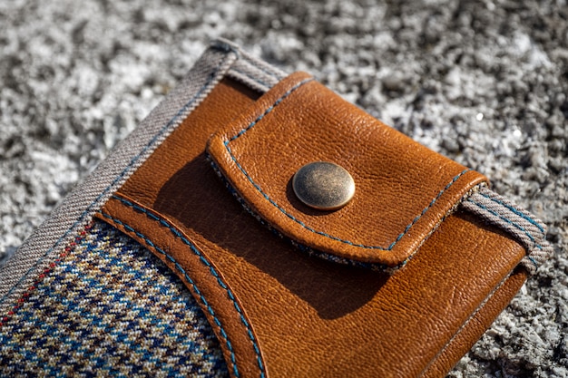 Handmade wallet of brown leather and checkered textile