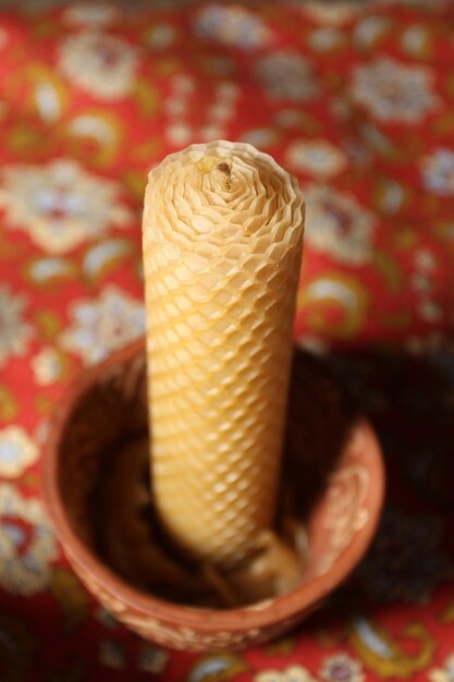 Handmade wax candles in a clay pot