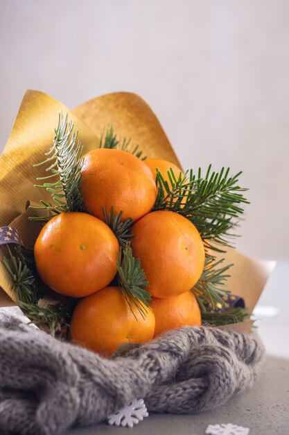 Handmade winter fruit bouquet of mandarin and Christmas tree branches