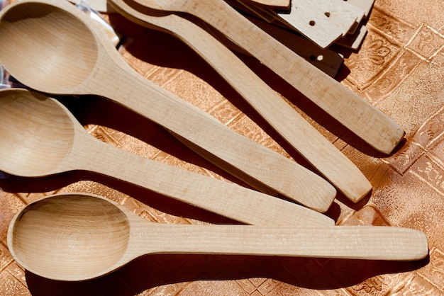 Handmade wood spoons on wooden table under sun. High quality photo