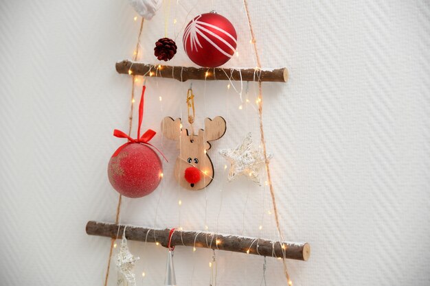 Photo handmade wooden christmas tree with toys hanging on the wall