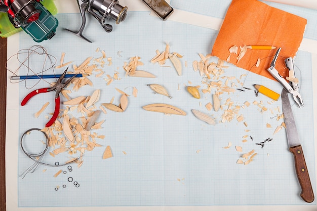 Fondo di carta millimetrata di tacles di pesca in legno fatti a mano con strumenti e spazi vuoti.