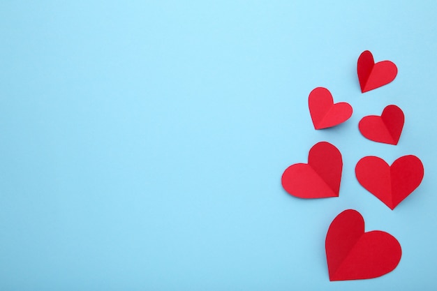 Handmaded red hearts on blue background.