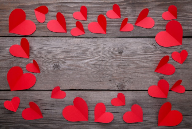 Handmaded red hearts on grey background.