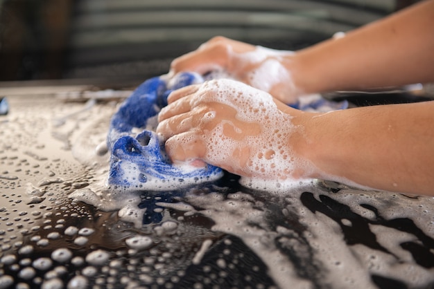 Handmatige carwash met blauwe carwashdoek