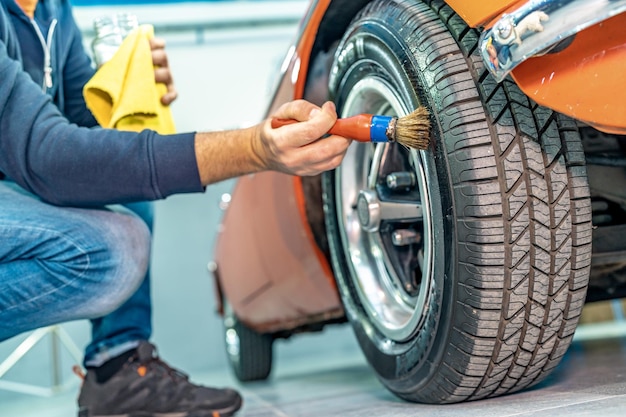 Handmatige reiniging van autowielen en banden in de garage