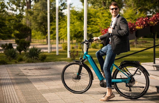 Handosme jonge zakenman op de ebike op straat