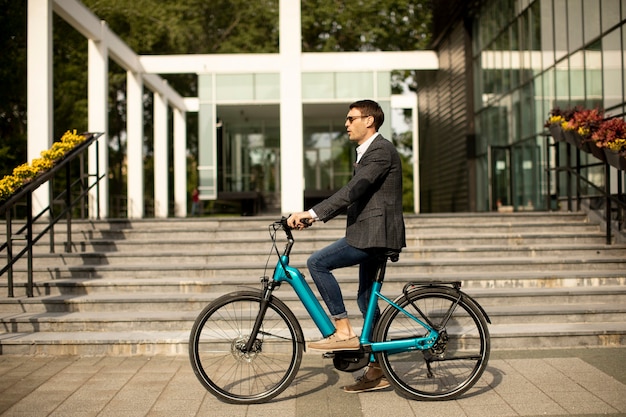 Handosme jonge zakenman op de ebike op straat