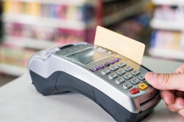 Handpers met het jatten van creditcard op betalingsterminal in opslag