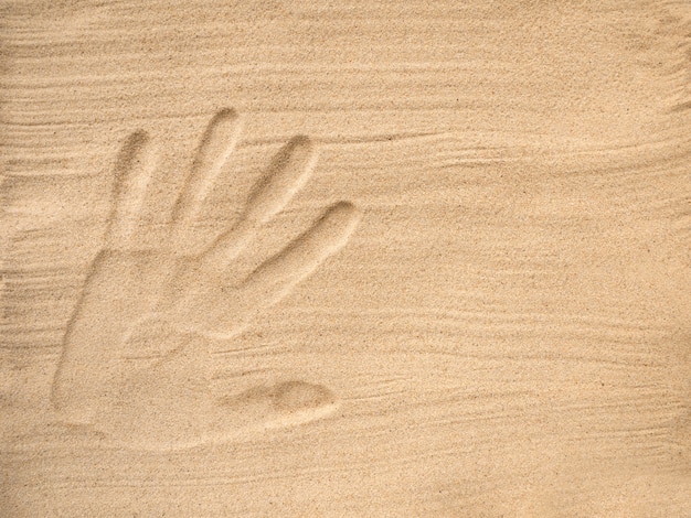 The handprint of a human hand in the sand