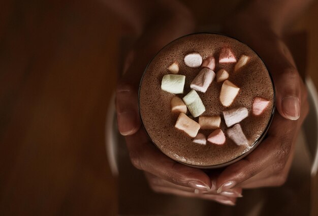 Hands of an African girl holding cocoa with a marshmallow