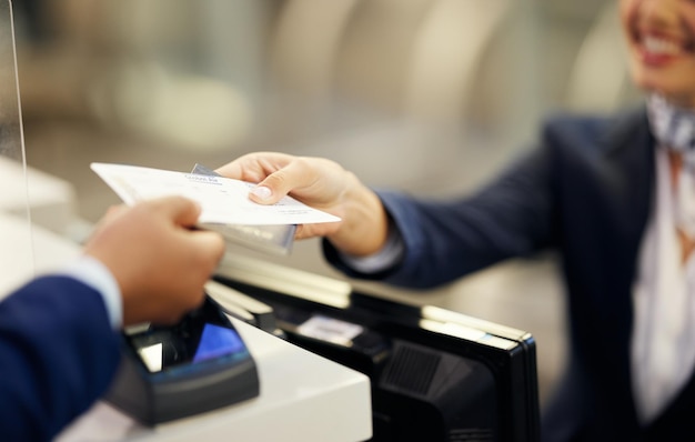 Hands airport and passenger assistant with ticket passport or documents to board plane at terminal counter Hand of female service agent giving access for travel security or immigration papers