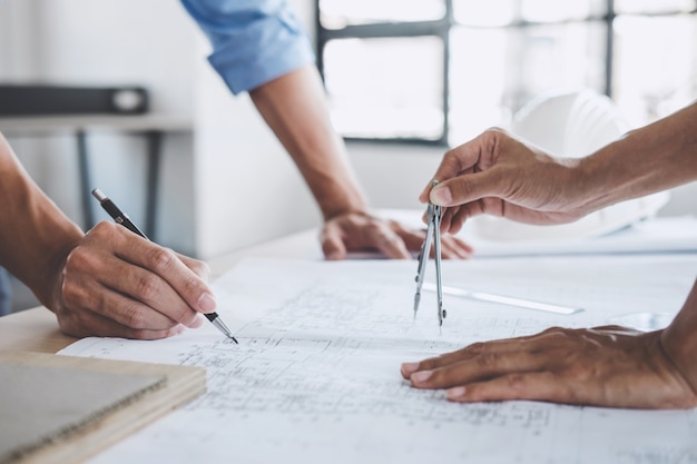 Hands of architect or engineer working on blueprint meeting for project working on model b