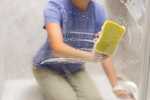 Photo hands are cleaning windows with sponge and detergent