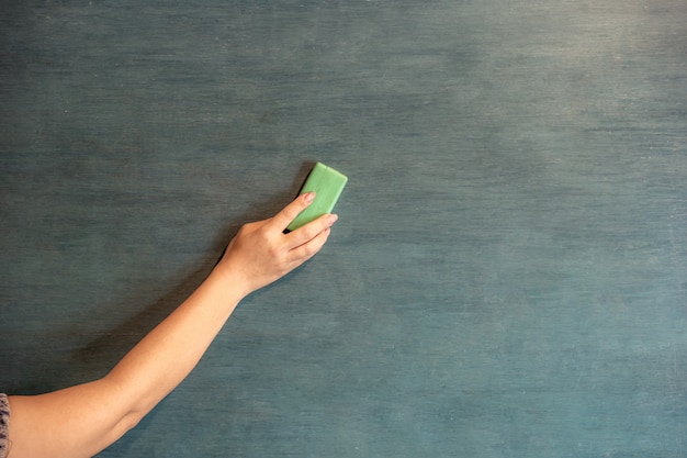 Hands are erasing the blackboard