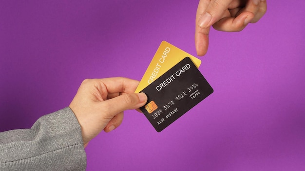 Hands are sent and receive black and gold credit cards on purple background