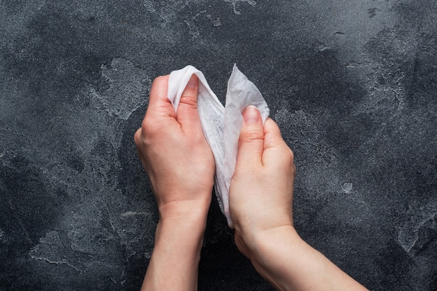 Hands are wiped with a damp antibacterial cloth on concrete