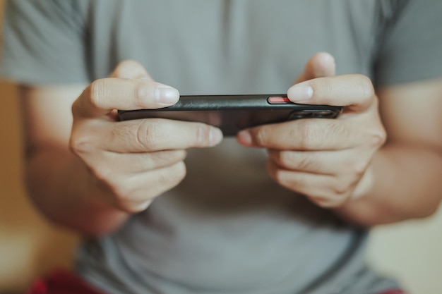 Photo hands of asian man playing game on smartphone