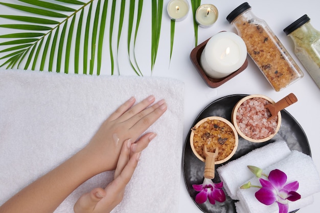 Hands of a beautiful woman dropping pine essential oil. Spa treatment and product for female hand spa, massage, candles, Relaxation. Flat lay. top view.