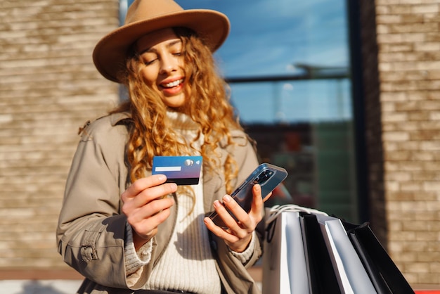 전화 신용카드를 가진 아름다운 여성의 손 온라인 쇼핑 개념 라이프 스타일 개념