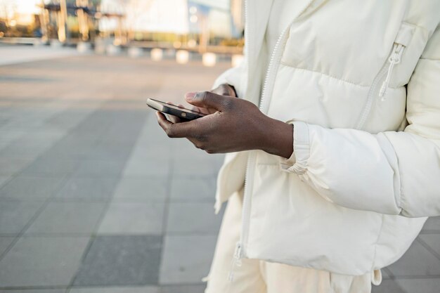 街でスマートフォンを使う黒人男性の手