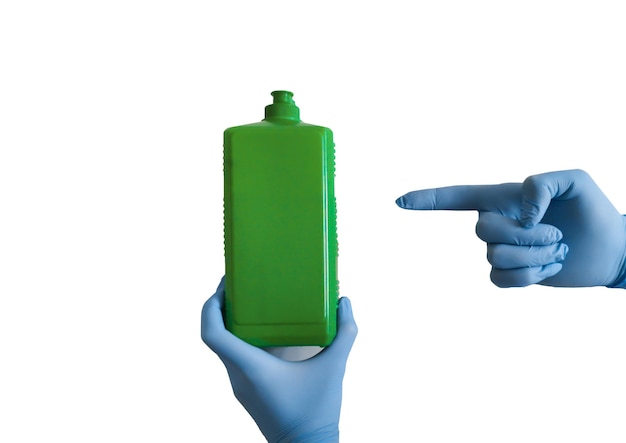 Hands in blue medical gloves are holding an antiseptic in a green bottle