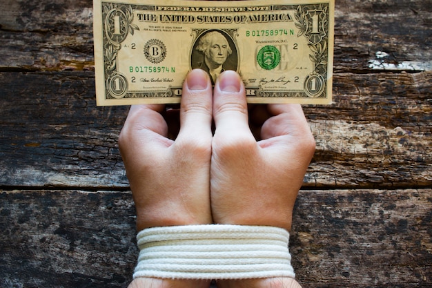 Photo hands bound men and money in the hands - a symbol of slavery