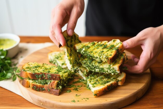 Hands breaking apart a piece of garlic herb grilled bread