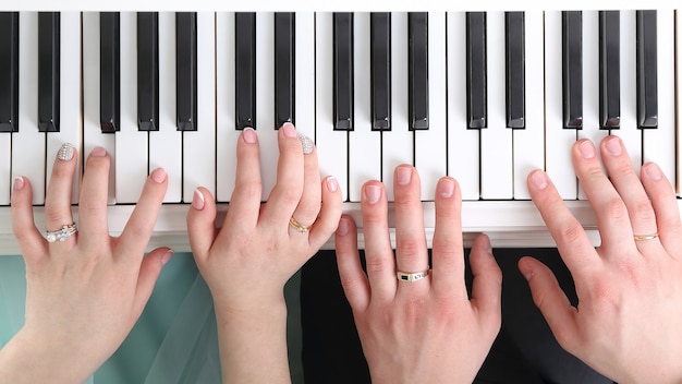 Hands of the bride and groom playing the piano. joint action in the new family Union