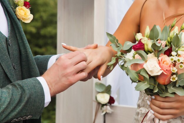 Mani sposa e sposo sul matrimonio cerimonia in stile irlandese nella casa del villaggio di campagna felice coppia scambiare fedi nuziali il mercoledì