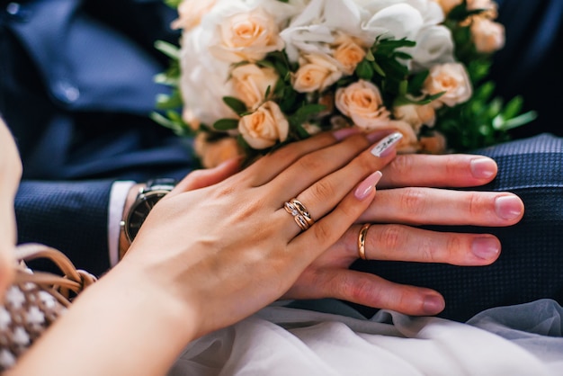 Hands of the bride and groom with gold rings on the wedding day together