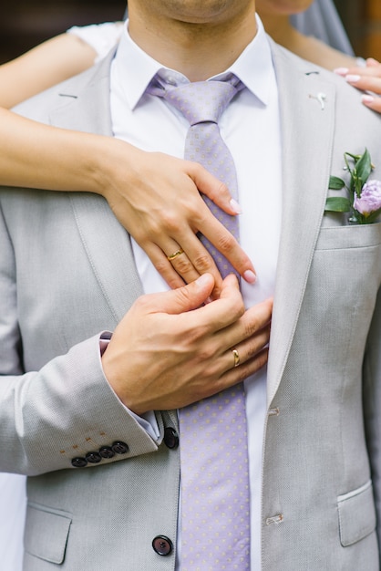 Hands of the bride and groom with wedding rings.