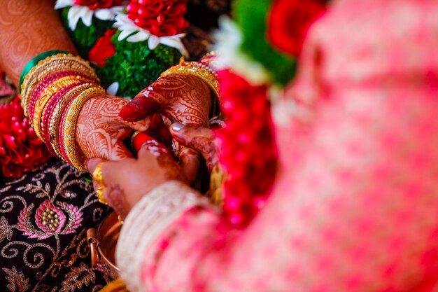 Photo hands of bride is decorated beautifully by indian mehndi art along with jewelerys and colorful bangles