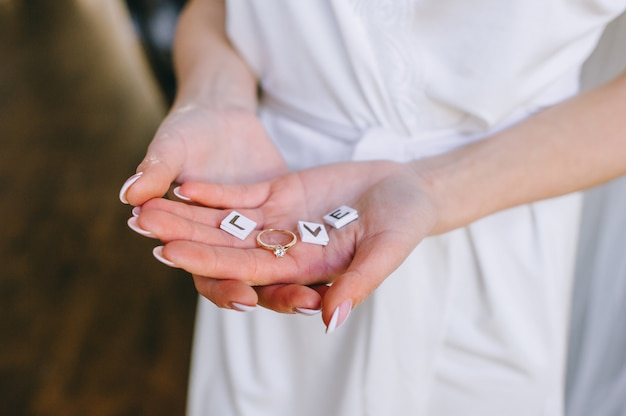 Photo hands of bride with cubes with the text of love