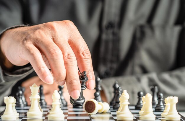 The hands of a business male business associate confident in strategy after playing chess to analyze and develop new planning Concept of leadership and teamwork for victory and success in business