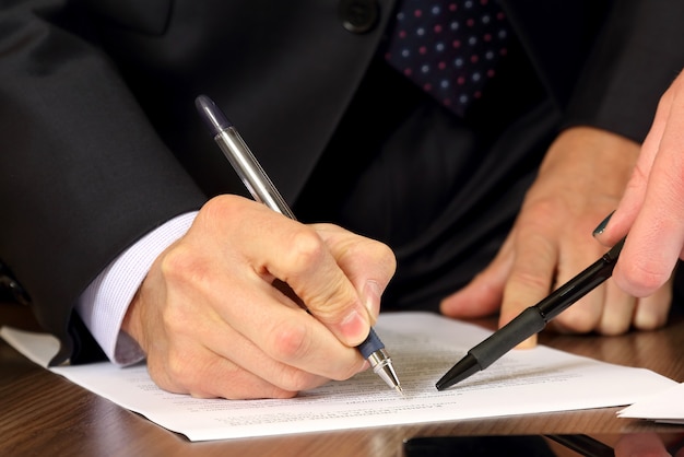 Hands of business men and women studying the documents