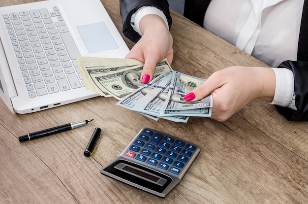 Hands of business woman counting dollar banknotes