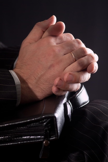 The hands of a businessman carrying a briefcase