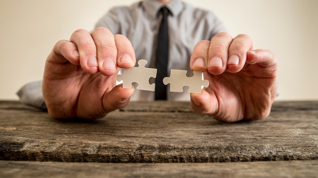 Photo hands of a businessman holding puzzle pieces