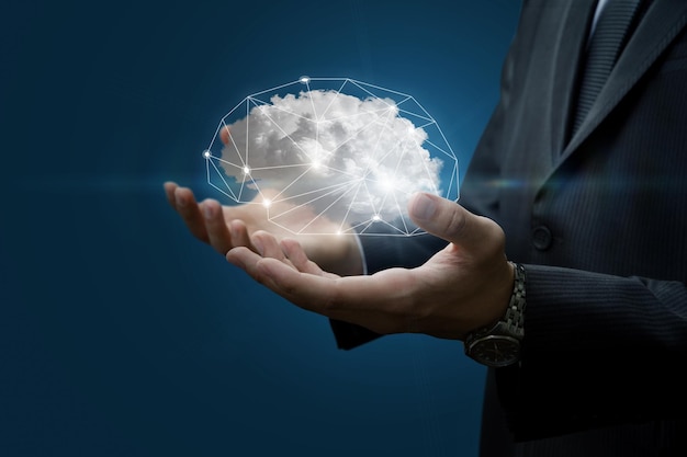 Hands of a businessman show the brain in the form of a cloud on a blue background