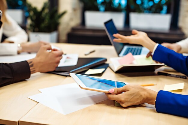 Hands of businesspeople working at desk in office