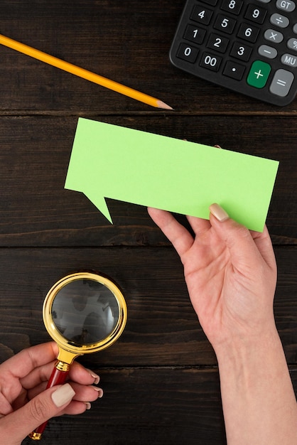 Hands Of Businesswoman With Thought Bubble Paper And Stationery Over Wooden Background Woman Holding Pastel Color Sheet With Copy Space For Business Branding And Promotion