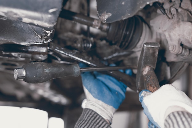 Hands of car mechanic in auto repair service.