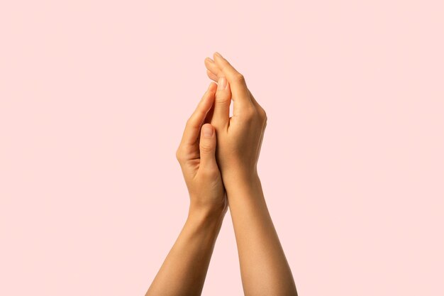 Photo hands care close up of moisturized beauty hands isolated on pink background