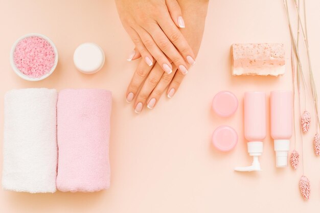 Hands care and pampering Spa treatment Cosmetic products on coral pink background