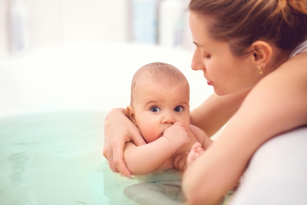 Hands of a careful unknown mother hold boy