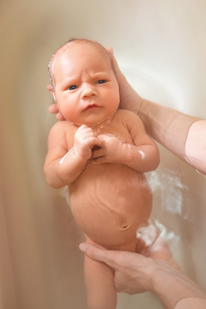 Hands of a careful unknown mother hold boy