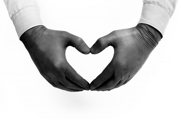 Hands of a caring doctor in medical gloves on a white background show a heart with their fingers, a professional takes care of our health: a medical concept, a place for text