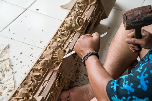 Hands of a carpenter making traditional wood  carving in Bali, Indonesia. Local craftmanship tradition concept