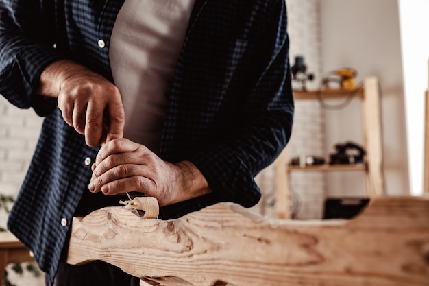 Photo hands of a carpenter working with chisel and hammer